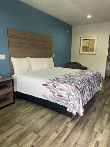 a bedroom with a large bed and a wooden floor at Delux Inn Cleburne in Cleburne