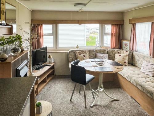 a living room with a table and a couch at Joys in Jaywick Sands