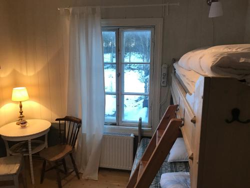 a room with a bed and a table and a window at Norrsjön in Sörsjön