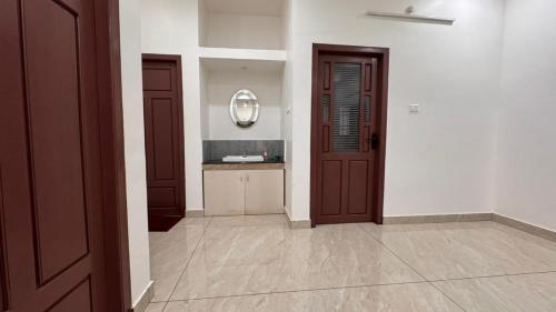 a hallway with two brown doors and a counter at Souparnika apartments in Varkala