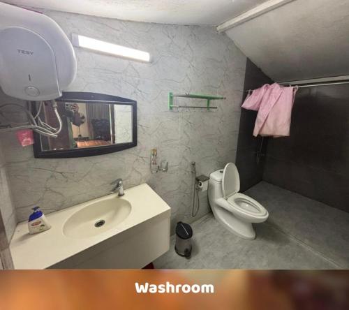 a bathroom with a sink and a toilet and a mirror at Sampan Cafe and Resort in Cox's Bazar