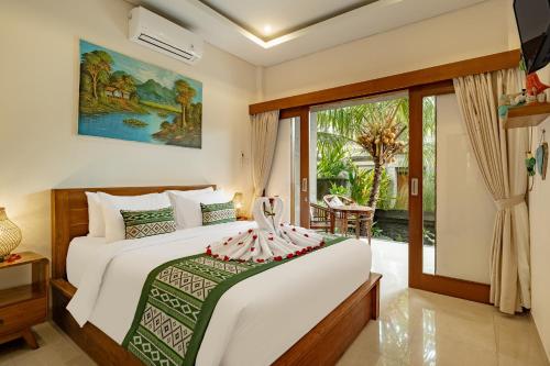 a bedroom with a bed and a large window at Orchid Ubud Cottage in Ubud
