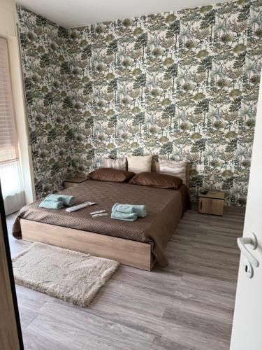 a bedroom with a large bed with a wall covered in wallpaper at Colombo 49 Guest House in Gallarate
