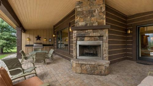 a patio with a stone fireplace on a house at BOTHR Steelhead in McCall