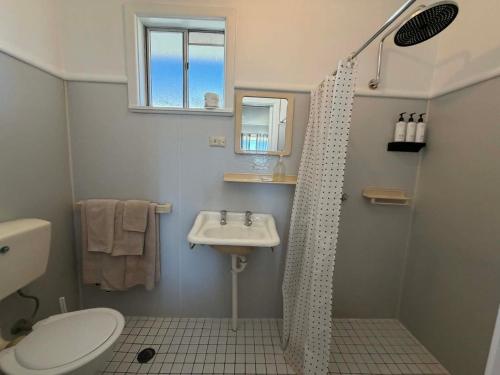 a bathroom with a shower curtain and a sink at Motel Bombala in Bombala