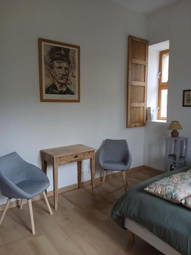 a bedroom with a bed and a table and two chairs at Gradine et Boucharde in Le Monastier sur Gazeille
