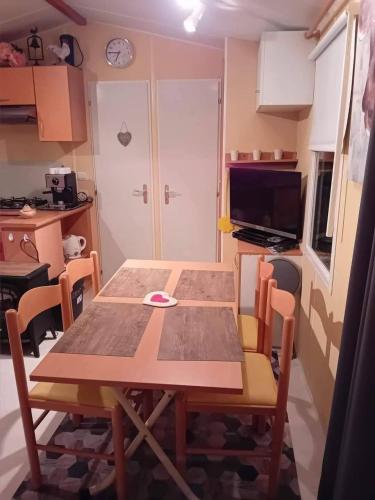 a table and chairs in a room with a kitchen at ROUPILLON A JANET in Curvalle