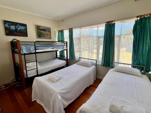 two bunk beds in a room with green curtains at & Art Motel in Tootgarook