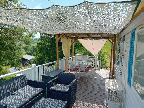 a deck with chairs and a table on a house at ROUPILLON A JANET in Curvalle