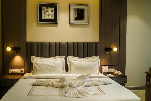 a bedroom with a bed with a white flower on it at Hotel PRD Palace in Saharsa