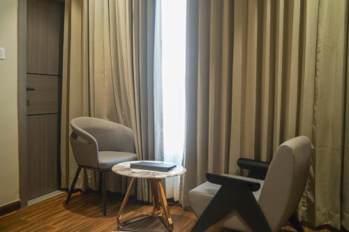 a room with two chairs and a table and a window at Hotel PRD Palace in Saharsa