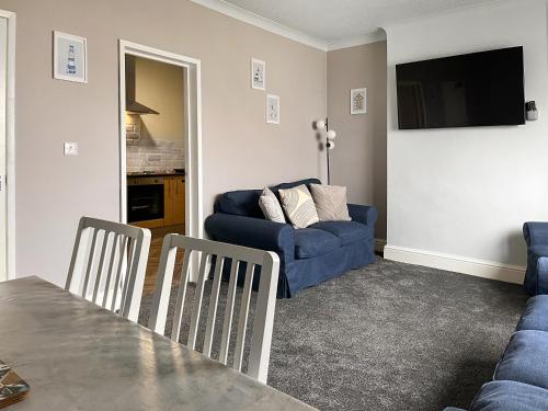 a living room with a blue couch and a table at Primrose - Uk49360 in Bridlington
