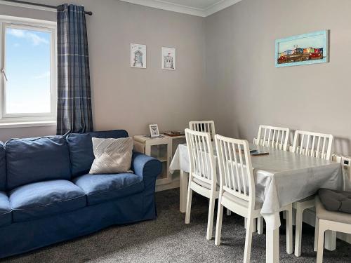 a living room with a blue couch and a table and chairs at Primrose - Uk49360 in Bridlington