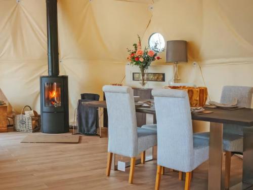 a dining room with a table and a wood stove at The Tree Dome - Ukc6979 in Ludlow