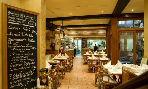 a restaurant with tables and chairs and a chalkboard at Central-Hotel Kaiserhof in Hannover