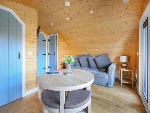 a living room with a table and a blue couch at Katie's Pod in Acharacle