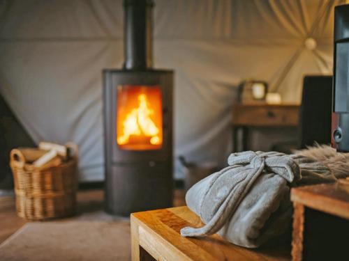 a room with a fireplace and a table with at The Star Dome - Ukc6978 in Ludlow
