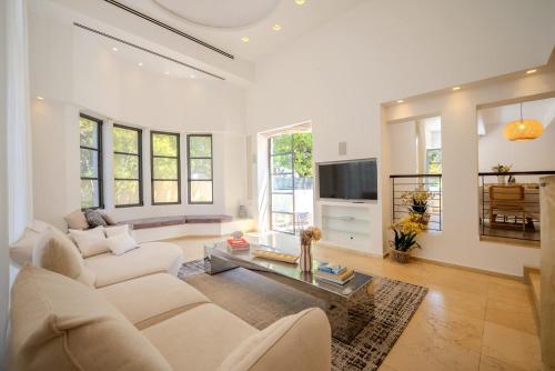 a living room with a couch and a table at Carmelo I MOD Villa in Herzliya B