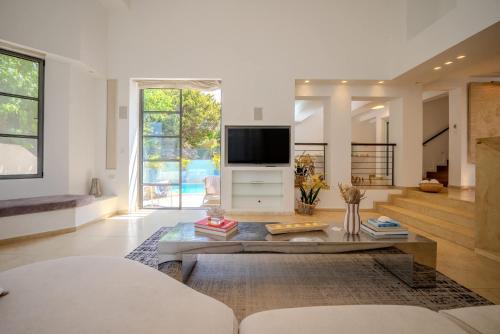 a living room with a tv and a table at Carmelo I MOD Villa in Herzliya B