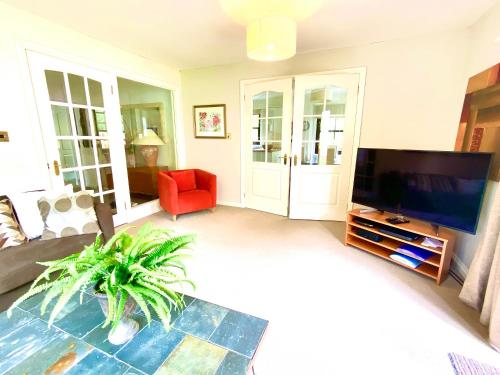 a living room with a television and a red chair at Lochindaal in Tarbert