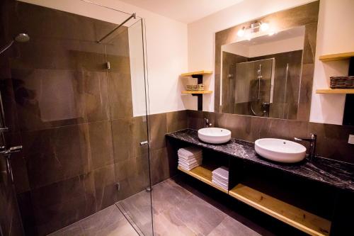 a bathroom with two sinks and a glass shower at Apartment gmiatlich Wohnen in Hollersbach im Pinzgau