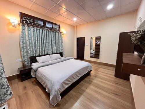 a bedroom with a large bed and a window at Valley Roots Homestay in Ziro