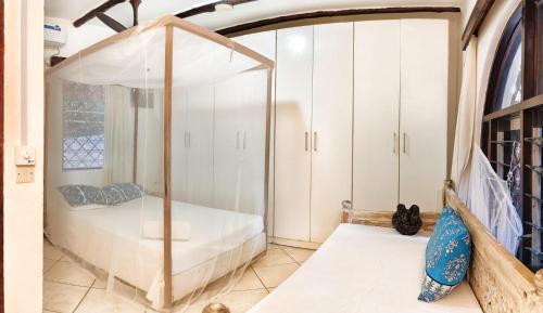 a bedroom with a bed with an umbrella at Villa Tewa in Mtwapa