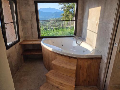 a bathroom with a tub with a large window at Casa Una Storia in Sartène
