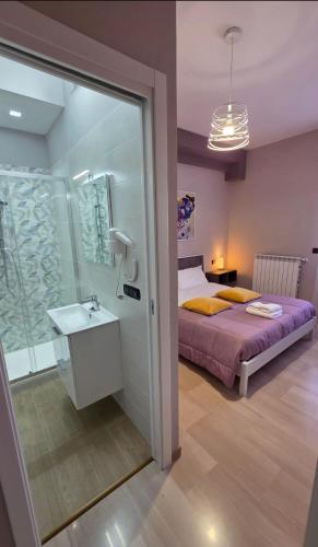 a bedroom with a bed and a sink and a mirror at ILBE bed & breakfast in Campobasso