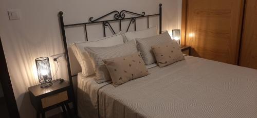 a bedroom with a bed with pillows and two lamps at Caldasia in Caldas de Reis