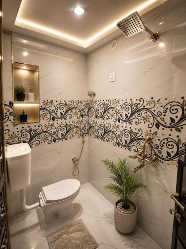 a bathroom with a toilet and a plant in it at Sudama Palace - Free Temple Pass For Guests in Ayodhya