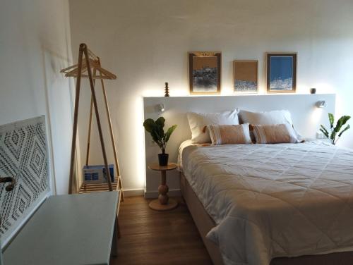 a bedroom with a large white bed with pillows at Gaia in Posidhonía