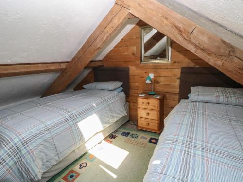 a attic bedroom with two beds and a window at Butterslade in Swansea