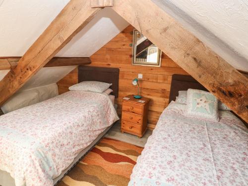 two beds in a attic bedroom with wooden walls at Ramsgrove in Swansea