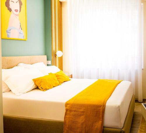 a bedroom with a bed with yellow sheets and a window at N'Ador Rooms in Naples
