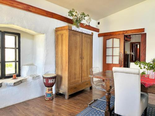 a dining room with a table and a wooden cabinet at Ziggiho chalupa in Pliešovce