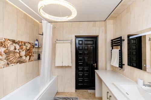 a bathroom with a tub and a sink and a mirror at Melissa's House in Cheltuitori