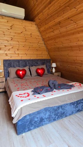 a bed with two red hearts on top of it at Thethi Sky Lodge in Theth