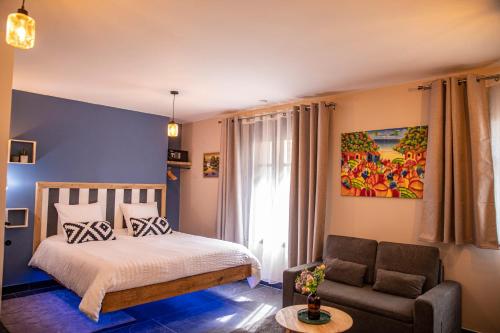 a bedroom with a bed and a couch at Maison Caliya in Saint-Didier-en-Velay