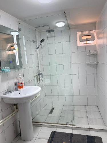 a white bathroom with a sink and a shower at Barlos Boutique XVIII in Bukhara