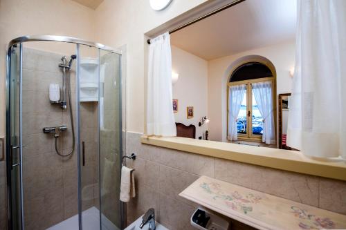 een badkamer met een douche en een spiegel bij Residence ANTICA PORTA Sul Mar in Rovinj