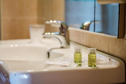 a bathroom sink with two bottles of toothpaste on it at Casa Levante - 3 camere, veranda e vista mare in Stintino