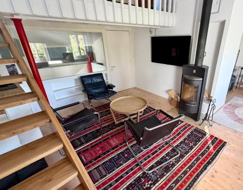 a living room with a table and chairs and a wood stove at Vue imprenable Léman - Cosy à Chexbres in Chexbres