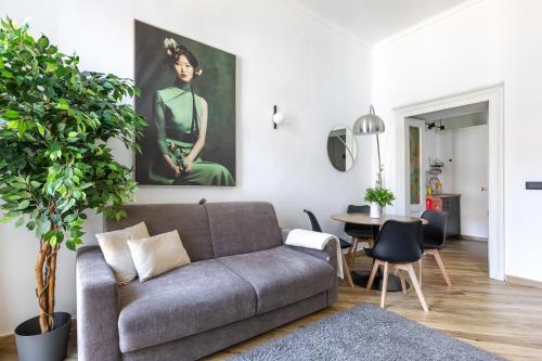 a living room with a couch and a painting on the wall at Le Monde Luxury Apartment in Turin