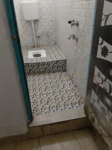 a bathroom with a toilet in the floor of a shower at Hotel Vasu in Gopālganj