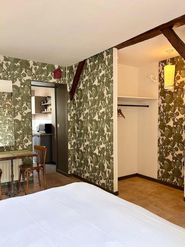 a bedroom with a bed and a table and a kitchen at Appartements 56 in Senlis