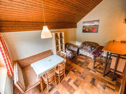a living room with a table and chairs in a room at Cosy holiday home in the Hochsauerland with terrace at the edge of the forest in Schmallenberg