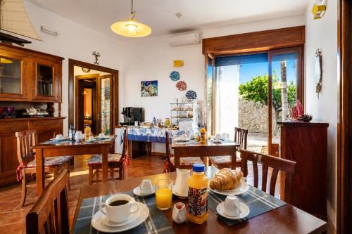 a dining room with a table with food on it at Le Chele - A Due Passi dal Mare in Torre Lapillo