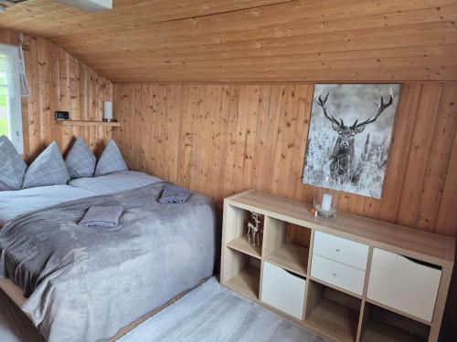 a bedroom with a bed and a picture of a deer at Seilbahnstubli in Ibergeregg