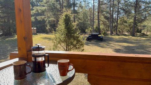 a table with a coffee maker on a porch with a grill at Nature Getaway Holiday Home in Mujaste